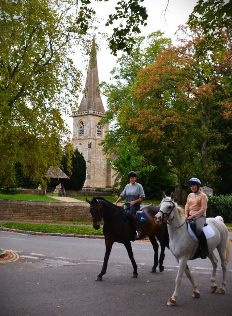 Church with Ladies on horses, Lower Slaughter Cotswolds England